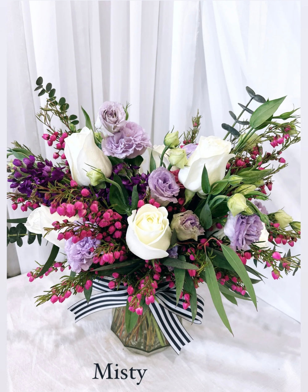 Large glass vase floral arrangement with fresh seasonal flowers